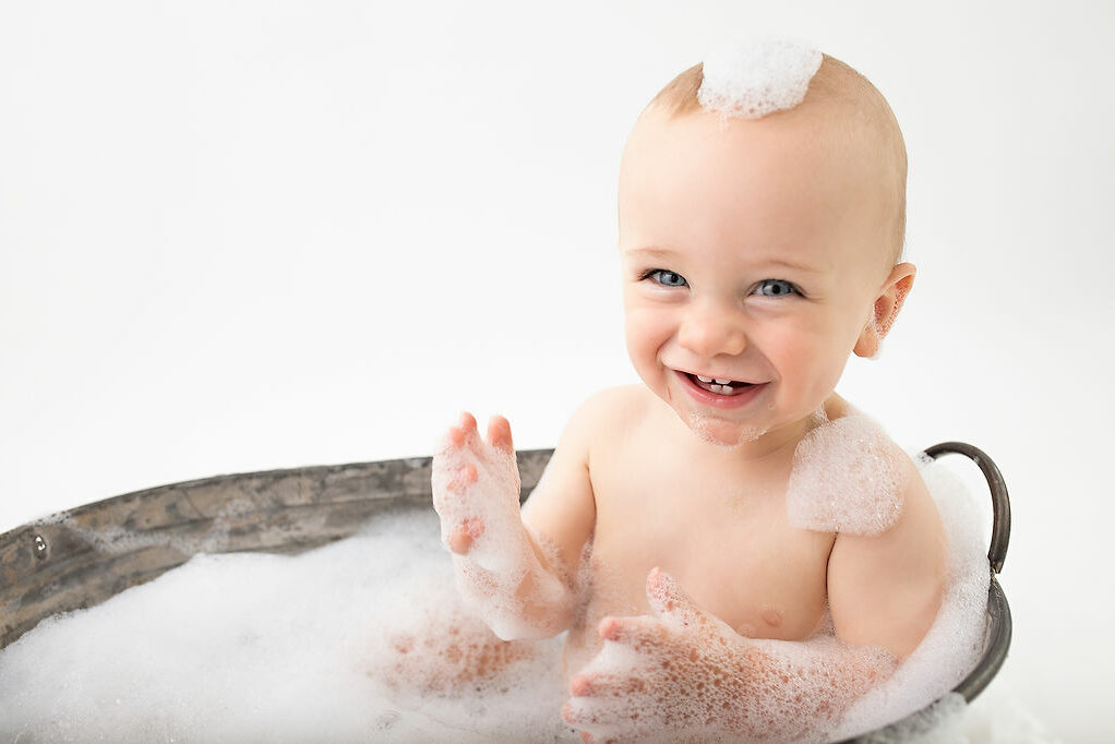 Milestone photography. First birthday photoshoot in Woking. Photographer Cheryl Catton. Baby in bath with bubbles