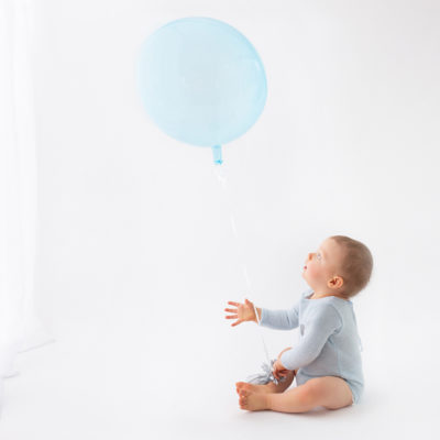 Cakesmash photo shoot, Baby boy playing with balloon during photoshoot, Milestone photography. First birthday photoshoot in Woking, Guildford photographer, Guildford Cake smash photographer, Guildford baby photographer
