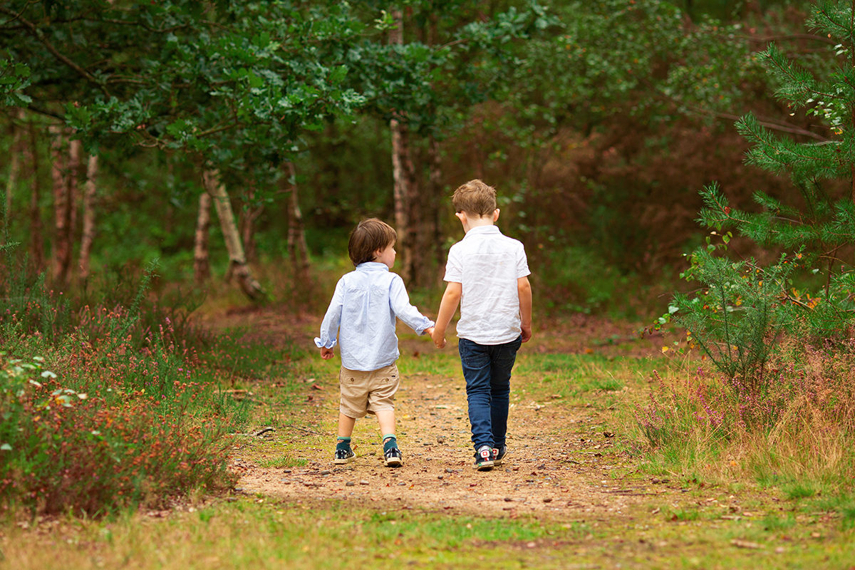 Brothers walking away holding hands on a family photoshoot in Woking